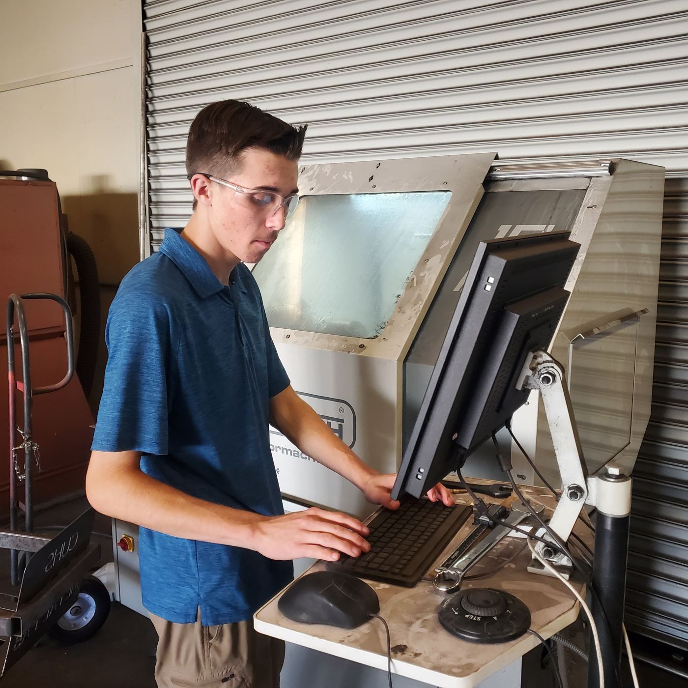 Un estudiante ejecuta un programa CNC desde la computadora del taller
