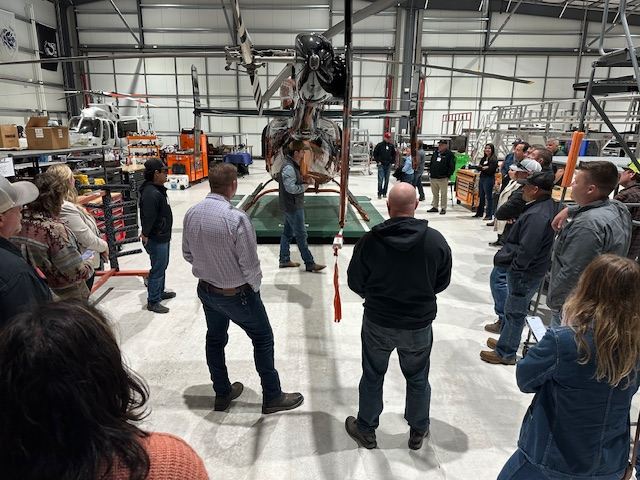 Empleadores y educadores recorren el hangar de PJ Helicopters durante el encuentro de empleadores