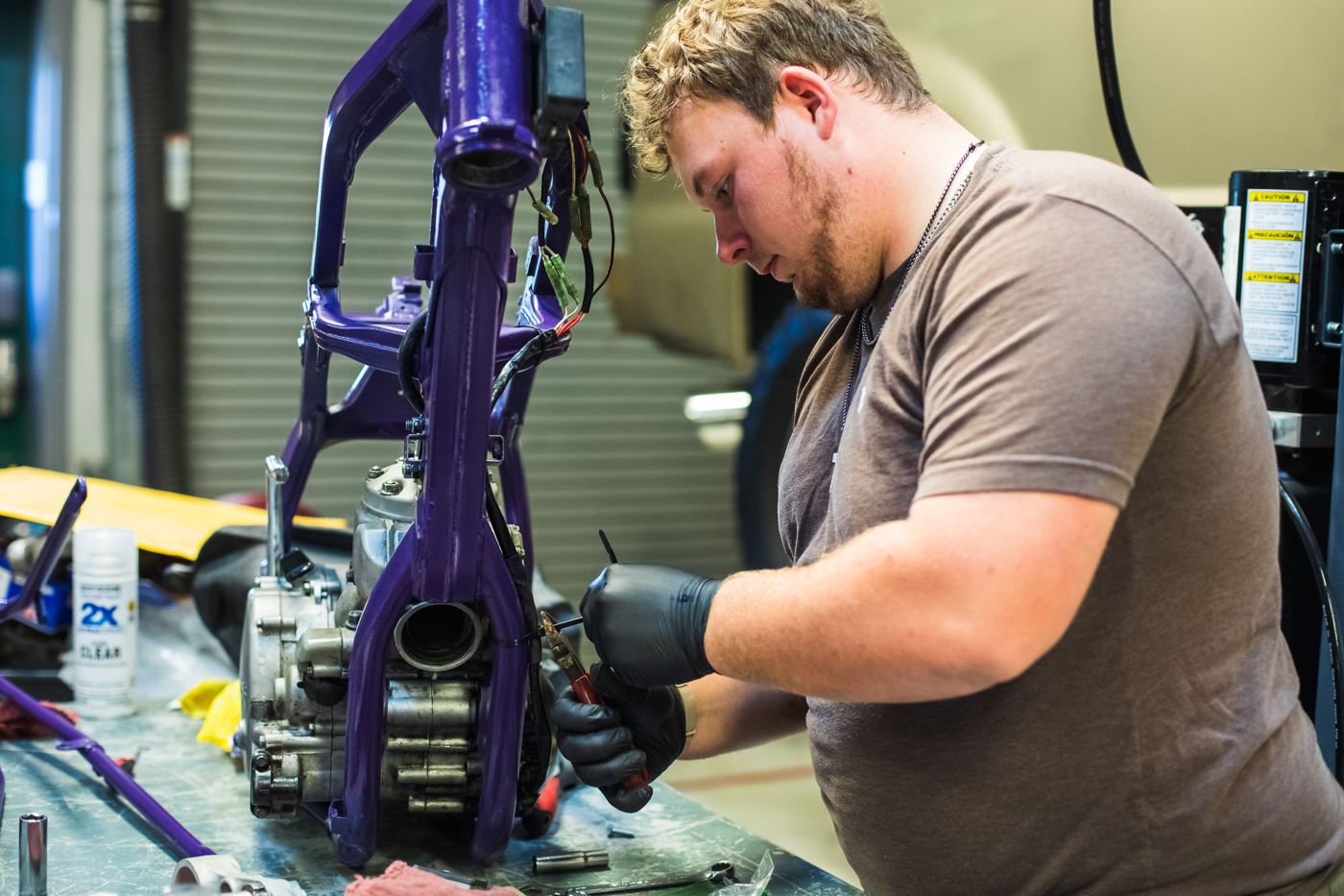 A student works on a metal frame in shop class